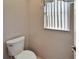This half bathroom features a toilet and a window with blinds at 1601 Westerly Dr, Brandon, FL 33511