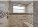 Tiled shower is complete with a built-in bench, mosaic tile accents, and a window at 1601 Westerly Dr, Brandon, FL 33511