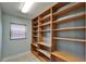 Spacious walk-in pantry with custom built-in wooden shelving, and a window for natural light at 1601 Westerly Dr, Brandon, FL 33511