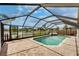 Screened pool with a lake view and waterfall, surrounded by brick pavers and a serene setting at 1601 Westerly Dr, Brandon, FL 33511