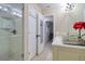 Bathroom with a walk-in shower, tile surround, and access to the bedroom at 16605 Round Oak Dr, Tampa, FL 33618