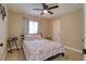 Cozy bedroom with a floral bedspread, ceiling fan, and natural light at 16605 Round Oak Dr, Tampa, FL 33618