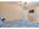 The bedroom features neutral tones, a ceiling fan, and a floral bedspread at 16605 Round Oak Dr, Tampa, FL 33618