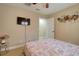 This bedroom features a television, neutral tones, and a floral bedspread at 16605 Round Oak Dr, Tampa, FL 33618