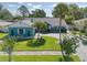 Charming blue home features a manicured lawn, paver driveway, and lush landscaping for great curb appeal at 16605 Round Oak Dr, Tampa, FL 33618