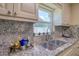 Close up of kitchen sink and granite counters, with window view at 16605 Round Oak Dr, Tampa, FL 33618