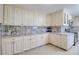Kitchen showcasing white cabinets, granite countertops, and tile flooring at 16605 Round Oak Dr, Tampa, FL 33618