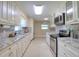 Bright kitchen features granite counters, white cabinetry, stainless appliances and tile flooring at 16605 Round Oak Dr, Tampa, FL 33618