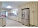 Open kitchen with white cabinets, granite counters, tile floors and stainless steel refrigerator at 16605 Round Oak Dr, Tampa, FL 33618