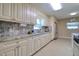 Updated kitchen boasts granite counters, white cabinets and stainless steel appliances at 16605 Round Oak Dr, Tampa, FL 33618
