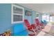 Outdoor patio with colorful chairs and mounted TV, offering a comfortable entertainment space overlooking the pool at 16605 Round Oak Dr, Tampa, FL 33618