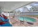 Screened in pool area with safety fence, brick pavers, and colorful patio furniture for outdoor relaxation at 16605 Round Oak Dr, Tampa, FL 33618