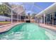 Screened-in pool with turquoise water surrounded by well-kept landscaping and cozy outdoor seating at 16605 Round Oak Dr, Tampa, FL 33618