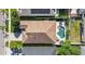 Drone shot displays a well-maintained roof, expansive backyard with pool, and neighborhood street with parked cars at 16802 Fairbolt Way, Odessa, FL 33556