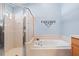 Bright bathroom features shower and a separate soaking tub with jets, surrounded by tile at 16802 Fairbolt Way, Odessa, FL 33556