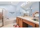 Bathroom featuring a glass enclosed shower, garden tub, and vanity with ample counter space at 16802 Fairbolt Way, Odessa, FL 33556