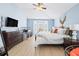 Bedroom features light-filled bay window, wood floors, ceiling fan and light blue paint at 16802 Fairbolt Way, Odessa, FL 33556