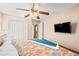 This bedroom features a ceiling fan, closet, mounted TV and views to the hallway at 16802 Fairbolt Way, Odessa, FL 33556