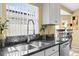 Close-up of the kitchen sink and countertop featuring stainless steel appliances and floral decor at 16802 Fairbolt Way, Odessa, FL 33556