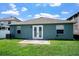 Backyard featuring a lush lawn and exterior view of the home with double doors and windows at 1755 Open Field Loop, Brandon, FL 33510