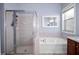 Bathroom featuring glass-enclosed shower and separate soaking tub with window at 1755 Open Field Loop, Brandon, FL 33510