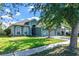 Well-maintained single-story home with a tidy lawn, mature trees, and a two-car garage at 1755 Open Field Loop, Brandon, FL 33510