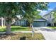 Charming single-story home featuring arched windows, a two-car garage, and a beautifully landscaped front yard at 1755 Open Field Loop, Brandon, FL 33510