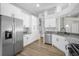 Modern kitchen featuring stainless steel appliances and white cabinets, granite counters and plank flooring at 1924 Sean Wood Cir, Brandon, FL 33510