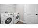 Bright laundry room with white washer and dryer, white wire shelf and access door at 1924 Sean Wood Cir, Brandon, FL 33510