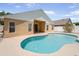 Back exterior view of kidney-shaped pool with covered patio attached to the house at 1924 Sean Wood Cir, Brandon, FL 33510