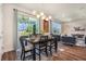 Bright dining area with a sliding glass door, modern lighting, and an open view to the living room at 21003 Monza Loop, Land O Lakes, FL 34638