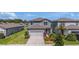 Beautiful exterior view of a two-story home, a manicured lawn, and a two-car garage at 21003 Monza Loop, Land O Lakes, FL 34638