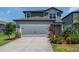 Charming two-story home featuring an attached two car garage and beautiful landscaping at 21003 Monza Loop, Land O Lakes, FL 34638