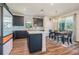 Stylish kitchen featuring navy cabinets, stainless appliances, quartz counters, island, and adjacent dining area at 21003 Monza Loop, Land O Lakes, FL 34638