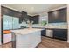 Modern kitchen features dark cabinets, stainless steel appliances, an island with quartz countertops, and stylish backsplash at 21003 Monza Loop, Land O Lakes, FL 34638