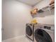 The laundry room has a side-by-side washer and dryer with a storage shelf at 21003 Monza Loop, Land O Lakes, FL 34638