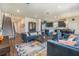 Spacious living room featuring modern furniture, a staircase, and an open-concept kitchen and dining area at 21003 Monza Loop, Land O Lakes, FL 34638