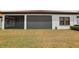 Back exterior showcases the lanai, yard, and design of the home's exterior at 21746 Amelia Rose Way, Land O Lakes, FL 34637