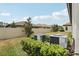 Landscaped backyard features a well-maintained lawn, privacy fence, and efficient air conditioning units at 21746 Amelia Rose Way, Land O Lakes, FL 34637