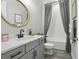 Stylish bathroom featuring modern vanity, a round mirror, and shower with bathtub at 21746 Amelia Rose Way, Land O Lakes, FL 34637