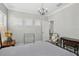 Bright bedroom features plantation shutters and a chandelier, providing a cozy and elegant space at 21746 Amelia Rose Way, Land O Lakes, FL 34637
