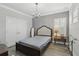 Charming bedroom features a stylish chandelier, elegant headboard, and natural light from the window at 21746 Amelia Rose Way, Land O Lakes, FL 34637