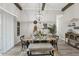 Dining room with wood beams and modern light fixture has a dining bench with seating for six at 21746 Amelia Rose Way, Land O Lakes, FL 34637