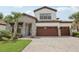 Elegant two-story home featuring a paver driveway, stone accents, and a spacious three-car garage at 21746 Amelia Rose Way, Land O Lakes, FL 34637