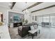 Open-concept living space featuring wood-look floors, exposed beams, and a cozy seating area at 21746 Amelia Rose Way, Land O Lakes, FL 34637