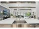 Open-concept living area featuring wood beam, stone accent wall, modern lighting, and large windows at 21746 Amelia Rose Way, Land O Lakes, FL 34637
