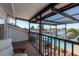 Balcony view of waterfront, pool, and outdoor kitchen features comfortable seating and relaxing view at 2202 Donato Dr, Belleair Beach, FL 33786