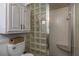 Bathroom with glass block shower, built-in seat, and storage cabinet at 2202 Donato Dr, Belleair Beach, FL 33786