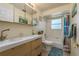Bathroom featuring a modern vanity with double sinks, a bathtub with shower, and beach-themed decor at 2202 Donato Dr, Belleair Beach, FL 33786