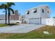 A two-story home with a white exterior, red roof, two-car garage, and a well-manicured lawn at 2202 Donato Dr, Belleair Beach, FL 33786